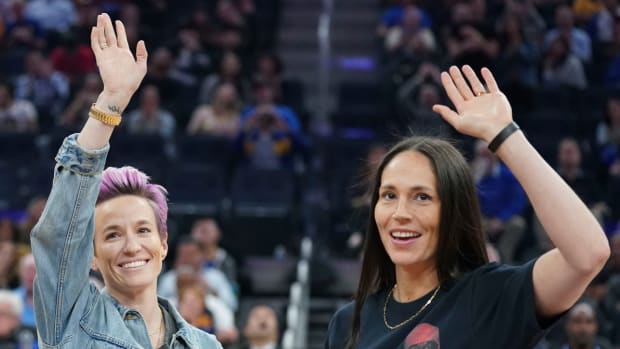 USWNT star Megan Rapinoe and WNBA star Sue Bird wave to the audience during a Warriors vs. Suns game in 2019.